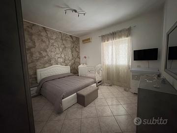 Cucina, camera da letto, divano, tavolo e sedie.