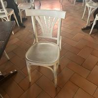 Sedie di legno bianche e due tavoli rotondi