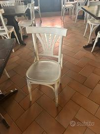 Sedie di legno bianche e due tavoli rotondi