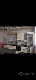 Cucina, tavolo sedie parete e divani