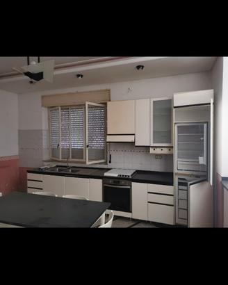 Cucina, tavolo sedie parete e divani