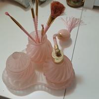 Set di oggetti per cosmetici in vetro rosa.