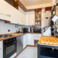 Cucina con elettrodomestici, tavolo e sedie