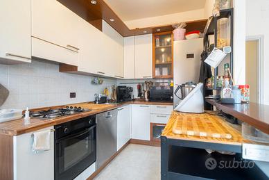 Cucina con elettrodomestici, tavolo e sedie