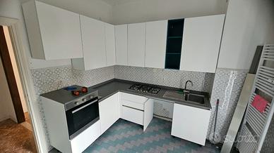 Cucina angolare moderna bianca con elettrodomestic