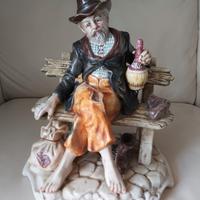 Statua anziano su panchina 