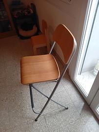 tre sgabelli in legno e alluminio. 