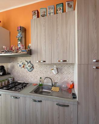 Cucina con elettrodomestici + tavolo e sedie