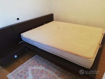 Letto matrimoniale in legno scuro e rete doghe