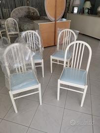 Sedie laccate bianche.