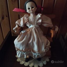 Bambola su sedia a dondolo 