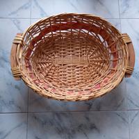 Cesto in vimini ovale con manici in legno.