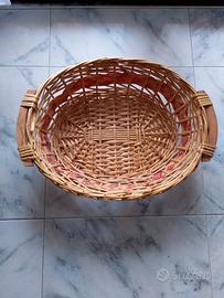 Cesto in vimini ovale con manici in legno.