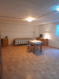 Camera singola arredata in locale seminterrato