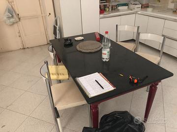 Tavolo rettangolare in marmo nero con 6 sedie.