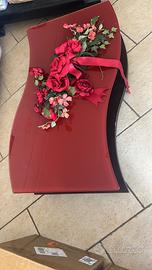 Tavolino basso in vetro e legno con ruote.