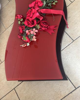 Tavolino basso in vetro e legno con ruote.