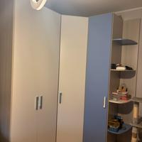 Camera con armadio ad angolo, libreria e comodino