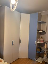 Camera con armadio ad angolo, libreria e comodino