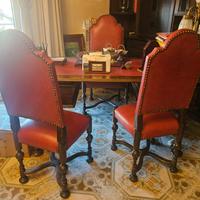 scrivania in legno con sedie e poltrona e libreria