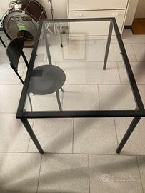 Tavolo in ferro e vetro con sedie nere