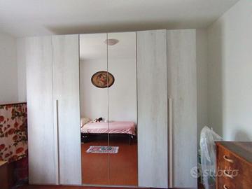 Armadio a 6 ante con specchio, due librerie, rete.