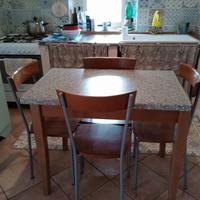 Tavolo di legno allungabile con quattro sedie.