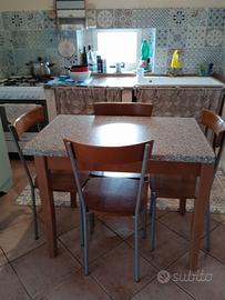 Tavolo di legno allungabile con quattro sedie.