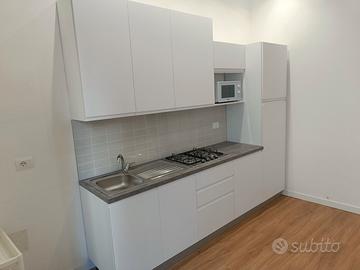 cucina con frigorifero e cappa