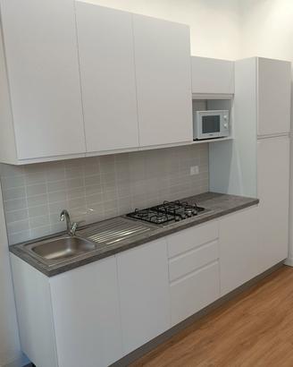 cucina con frigorifero e cappa