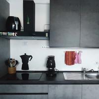 cucina grigia cemento con elettrodomestici tavolo