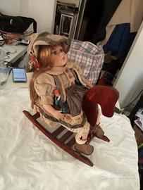Bambola su sedia a dondolo 