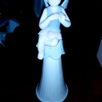 Bambina con le ali seduta su una campana di porcel