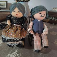 Coppia di bambole di pezza su una sedia a dondolo