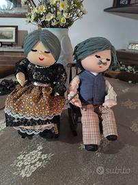 Coppia di bambole di pezza su una sedia a dondolo