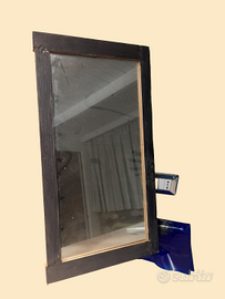 Specchio con una cornice in legno scuro, dal desig