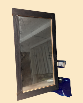 Specchio con una cornice in legno scuro, dal desig