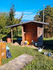 casetta in legno con legnaia