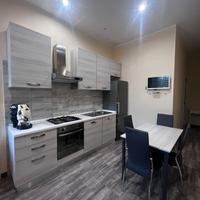 cucina con tavolo sedie e mobile arredo bagno