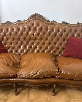 salotto vintage in pelle e in legno intagliato