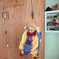 Clown in stoffa in altalena