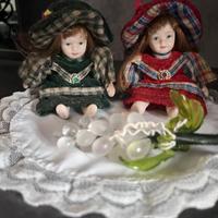 Coppia di bamboline in porcellana con vestiti