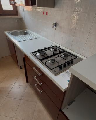 Cucina con piano cottura e frigo.