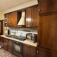 Cucina in legno, con tavolo e credenza