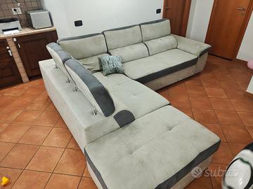 divano angolare con letto estraibile e pouf.