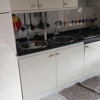 Cucina bianca ad angolo in legno con top in marmo