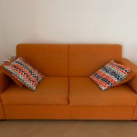 Divano letto color arancio con cuscini inclusi