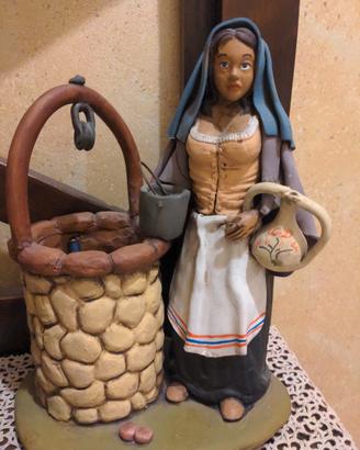 statuetta con donna e pozzo