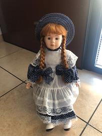 Bambola seduta su sedia a dondolo