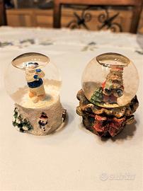 2 sfere di vetro natalizie con la nevicata interna